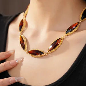 Detailed shot of a vintage gold necklace with marquise-cut amber crystals on a model.