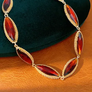 Close-up of retro palace style necklace with red marquise stones in gold-toned setting
