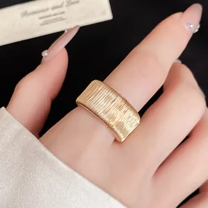 Detailed view of a gold geometric woven open ring featuring a vintage textured metal finish