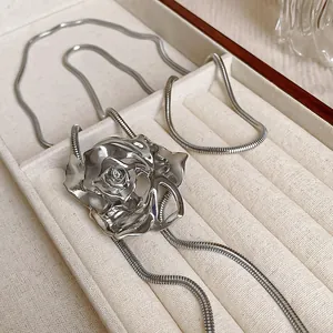 Close-up of a vintage silver rose pendant necklace presented in an ivory velvet jewelry box