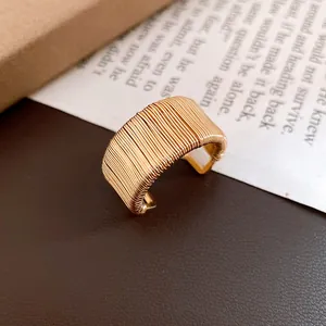 Macro view of a golden geometric wire-wrapped woven open ring with vintage style texture