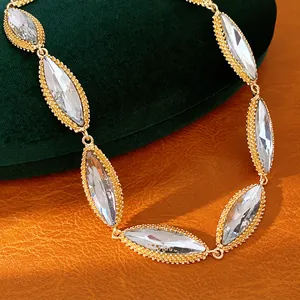 Close-up of retro palace style necklace with marquise-cut crystals in gold setting.