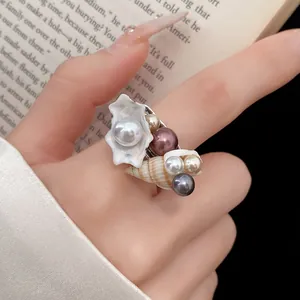 Dettaglio macro dell'anello bohémien con conchiglie e perle dal design marino unico