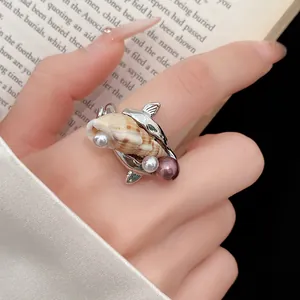 Dettaglio di un anello bohémien a conchiglia con perle e design ispirato all'oceano