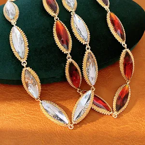Detailed view of marquise-cut red and clear crystal necklace in vintage gold setting