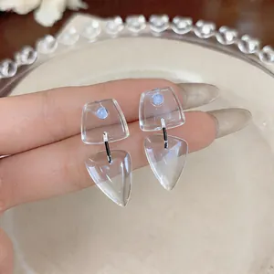 Vista macro de elegantes pendientes geométricos de resina transparente con diseño moderno