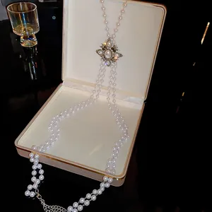 Detailed view of elegant multi-layer pearl waist chain with vintage decorative centerpiece