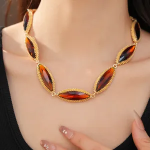 Close-up of vintage court style collarbone chain with amber marquise gemstones on model