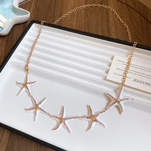 Detailed view of white and gold starfish charms on a retro ethnic style waist chain belt