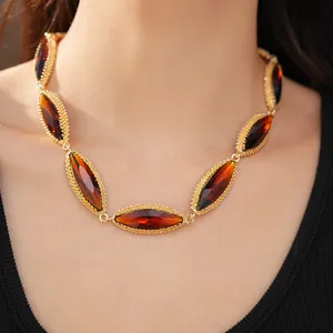 Close-up of vintage gold collarbone necklace with marquise-cut amber stones on model
