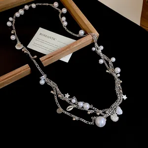 Close-up of vintage multi-layer pearl waist chain with shell and star pendant details