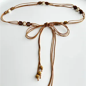 Close-up of ethnic style multi-layer brown cord waist chain with decorative beads