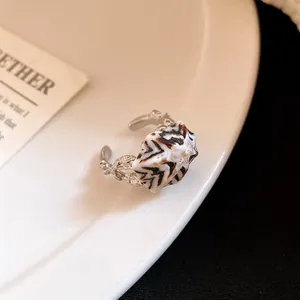 Macro dettagliata di un anello aperto a conchiglia bohémien con fascia in argento testurizzato