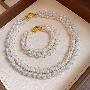 Detailed view of handmade white pearl beaded necklace and bracelet set in a jewelry tray