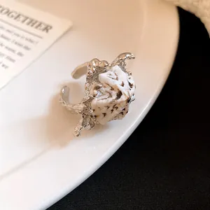 Dettaglio di un anello aperto bohémien in argento con elemento in conchiglia naturale