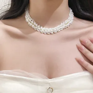 Macro detail of white crystal pearl beaded clavicle necklace worn on model's neck