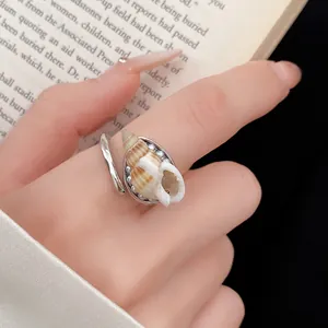 Primo piano dettagliato di un anello a conchiglia boho con texture naturali