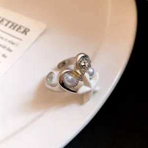 Primo piano dettagliato di un anello bohémien in argento con perle bianche e stella marina