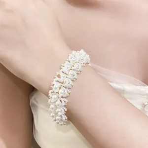 Close-up detail of an elegant handmade white pearl beaded bracelet worn on the wrist