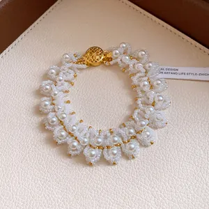 Close-up of elegant white pearl beaded choker necklace with golden filigree clasp
