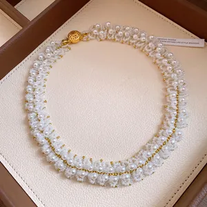Close-up of white crystal and pearl beaded necklace with elegant gold clasp detail