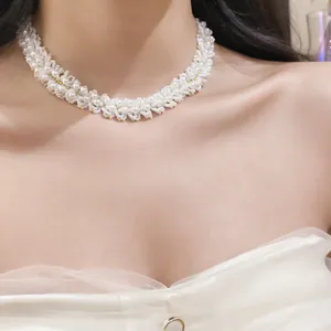 Detailed view of an elegant white beaded crystal pearl choker necklace on a model.