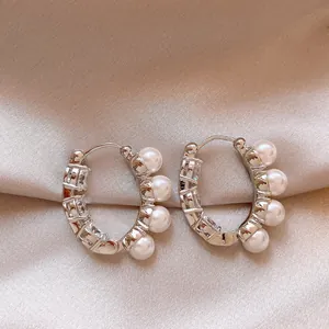 Detailed view of elegant silver hoop earrings with white pearls and sparkling zircons
