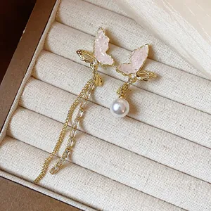 Asymmetrical 14k gold plated butterfly earrings with pearls and long tassels.