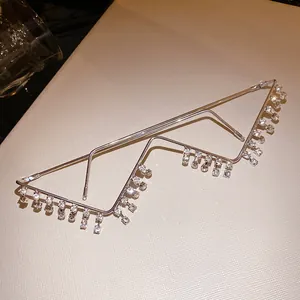 Detail of a metal lensless eyewear frame featuring sparkling rhinestone tassels