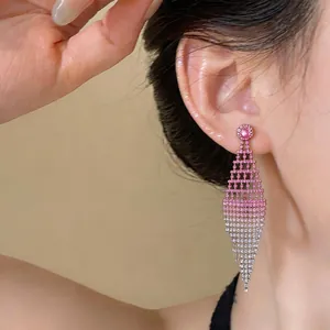 Primo piano di orecchini pendenti a rombo traforato con strass sfumati rosa e bianco