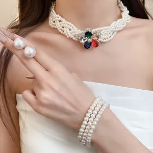 Elegante Nahaufnahme des mehrreihigen Perlen-Chokers und Armbands mit Edelsteinblume