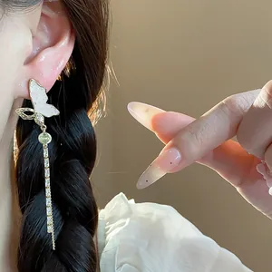 Detail of 14k gold plated butterfly tassel earring with sparkling stone accents.