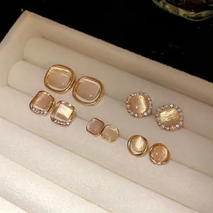 Elegant cat-eye stone stud earrings in various geometric shapes inside a jewelry box