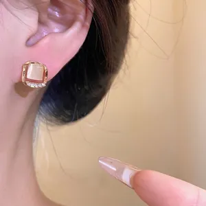 Elegant gold square stud earrings with cat-eye stone and sparkling rhinestones.