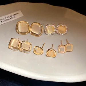 Elegant gold-tone cat's eye stud earrings with rhinestone accents in geometric styles