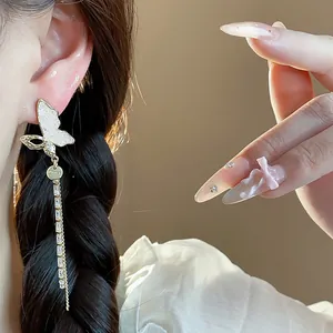 Close-up of 14k gold-plated butterfly tassel earrings worn with elegant French style.
