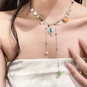 Vista detallada de un collar con colgante de hoja con cuentas y lentejuelas de colores