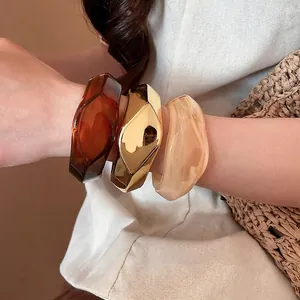 Set di tre grossi bracciali irregolari in resina ambrata e finitura oro
