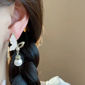 Close-up of 14k gold plated butterfly stud earrings with elegant white pearl drops