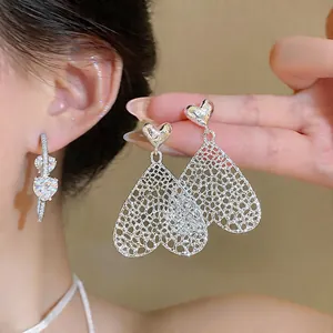 Exquisite Detailansicht silberne Herz-Ohrringe mit elegantem durchbrochenem Netz-Design