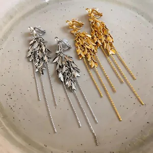 Detailansicht eleganter gold- und silberfarbener Weizenähren-Clip-Ohrringe mit Quasten.