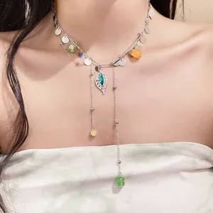 Vista detallada de un collar con borla de hoja de plata, cuentas y lentejuelas