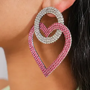 Detalle de pendientes de corazón con brillantes rosas y blancos.