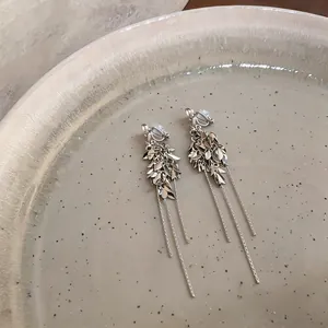 Nahaufnahme eleganter Weizenähren-Ohrclips mit zarten, langen Kettchen-Quasten in Silber