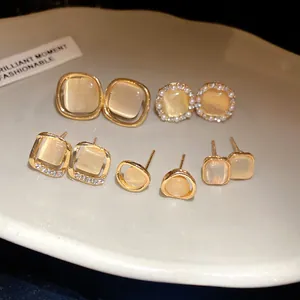 Selection of cat-eye stone stud earrings with rhinestone accents in gold plating