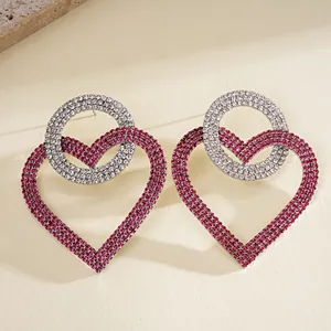 Primer plano detallado de lujosos pendientes de corazón rosa y círculo de diamantes