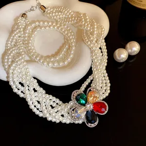 Detailansicht einer Vintage-Perlenkette mit bunter Strassblume im französischen Stil