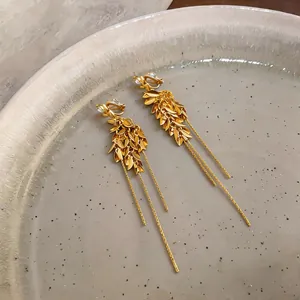 Detaillierte Ansicht eleganter goldener Weizenähren-Ohrclips mit langen Goldquasten