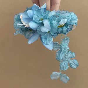 Detail view of blue fabric flower hair clip featuring an elegant hanging floral tassel.