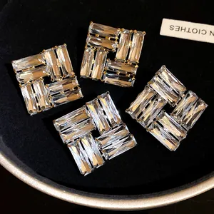 Dettaglio macro di orecchini a lobo geometrici di lusso con cristalli trasparenti